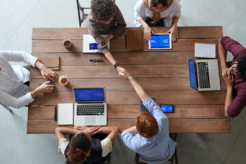 people sitting around table working on laptops